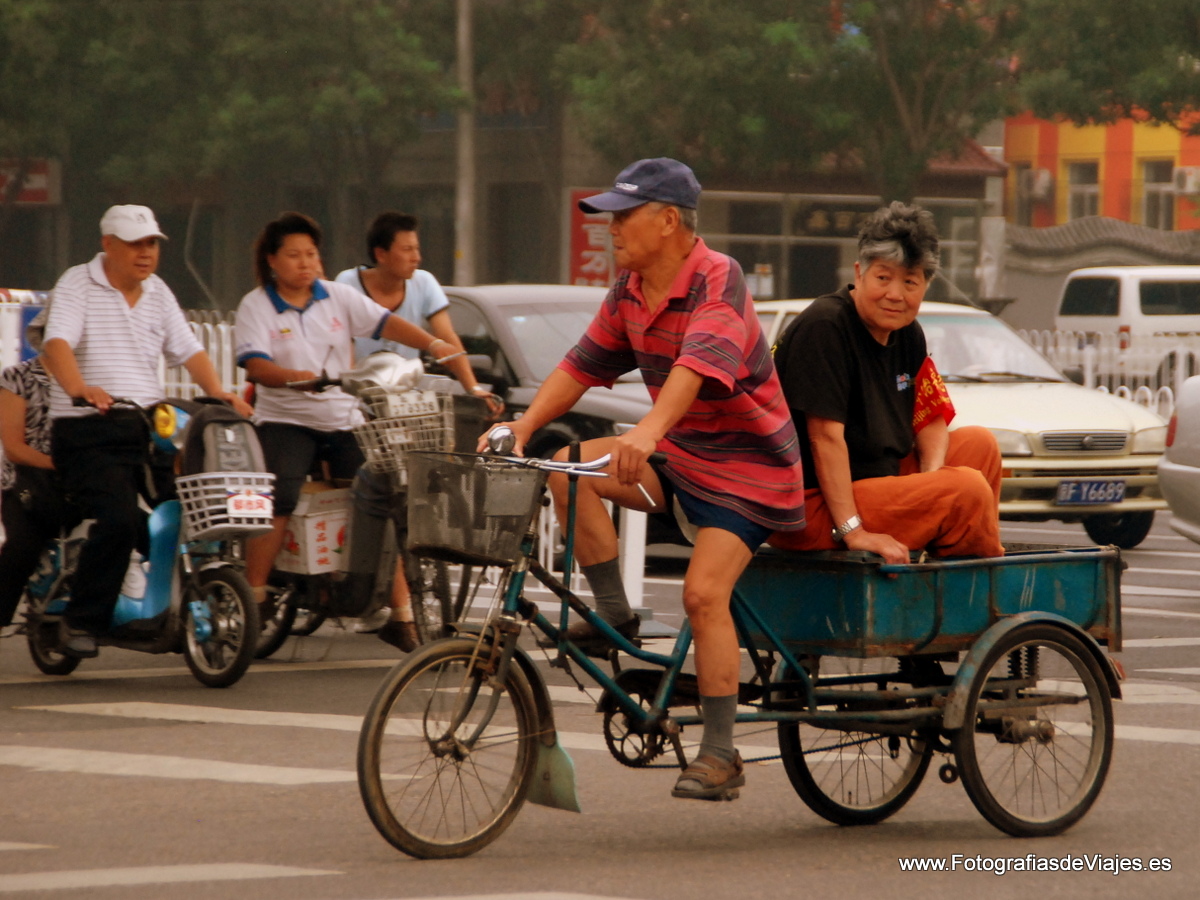 Ciudadanos chinos en bicicleta tradicional en Pekín